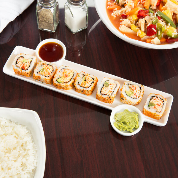 An American Metalcraft porcelain tray with sushi, rice, and sauce on a table.