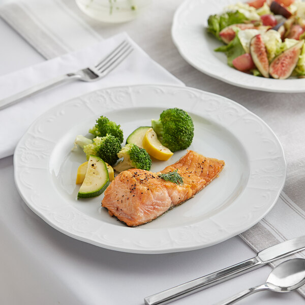 A Tuxton Chicago bright white china plate with salmon and vegetables on it.