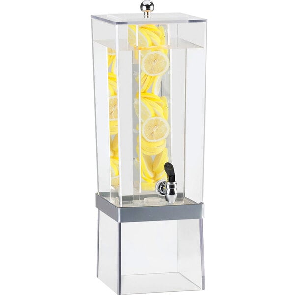 A Cal-Mil silver beverage dispenser with an infusion chamber and lemons inside.