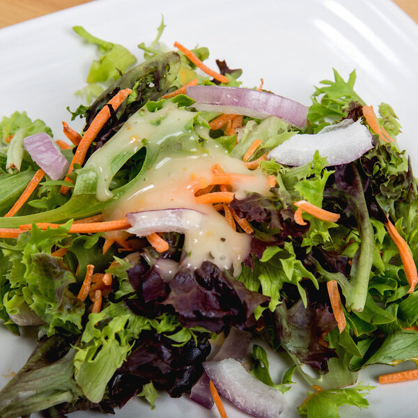 A salad on a plate with carrots and lettuce.