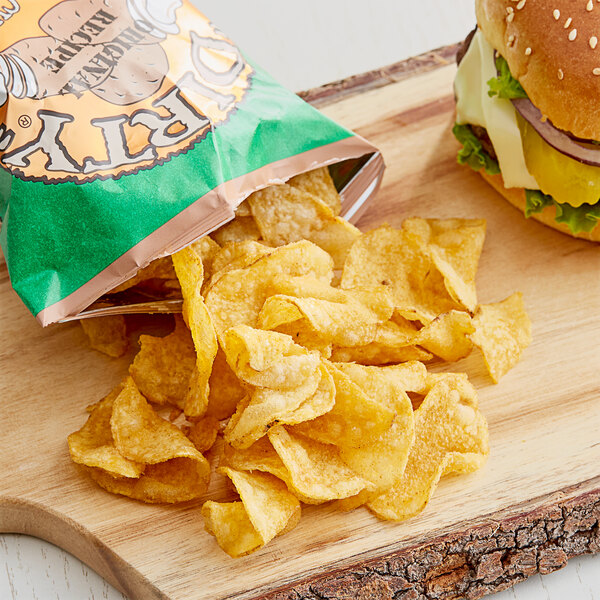 A bag of Dirty Jalapeno Heat Potato Chips next to a burger on a table.