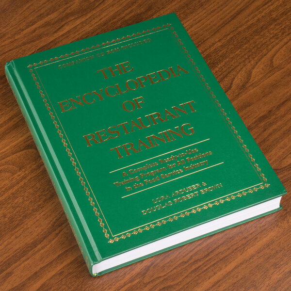 The Encyclopedia of Restaurant Training, a green book with gold text on a wood surface.