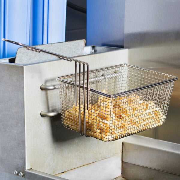 A Cecilware fryer basket with a wire mesh bottom filled with french fries.