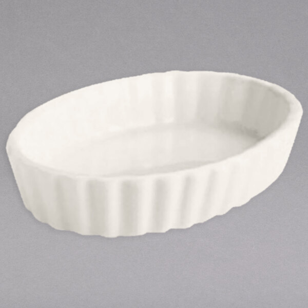 A white oval shaped Hall China fluted souffle dish.
