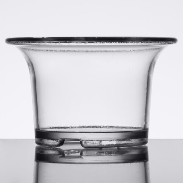 A clear plastic oyster cup with a rim on a table.