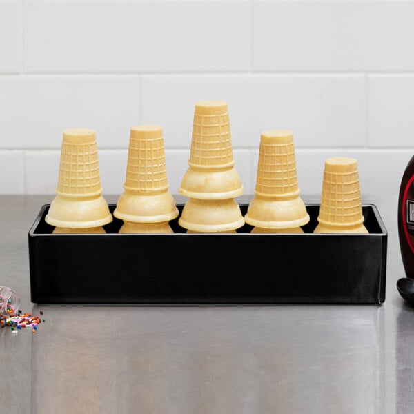A black Cal-Mil melamine box holding ice cream cones on a counter.