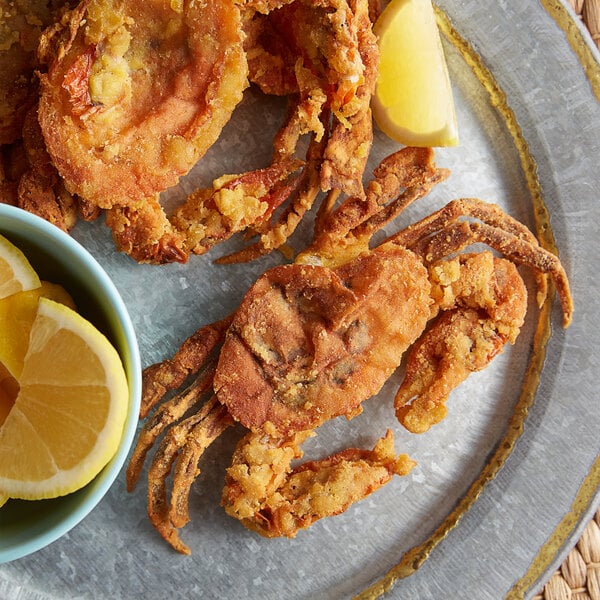 A plate of fried J.O. Soft Shell Crab with lemon wedges.