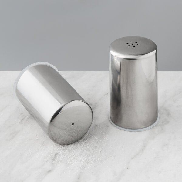 An American Metalcraft stainless steel salt and pepper shaker set on a marble surface.