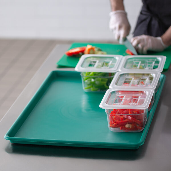 A person using a Channel green plastic tray to prepare food.