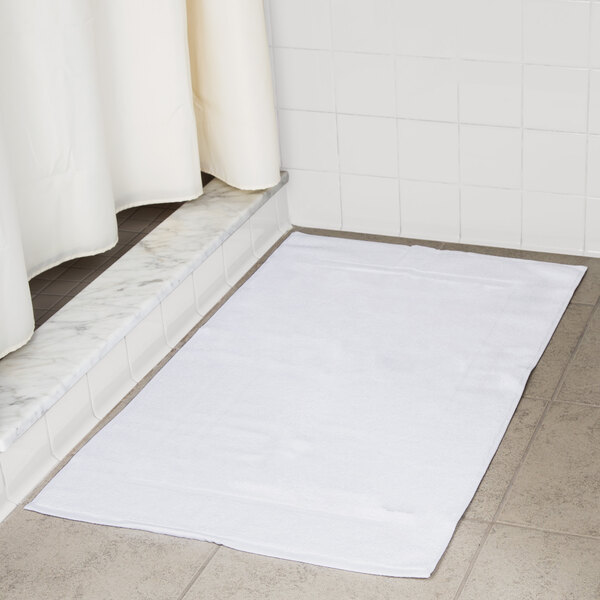 A white Oxford Platinum bath mat with a dobby twill hem on a tile floor.