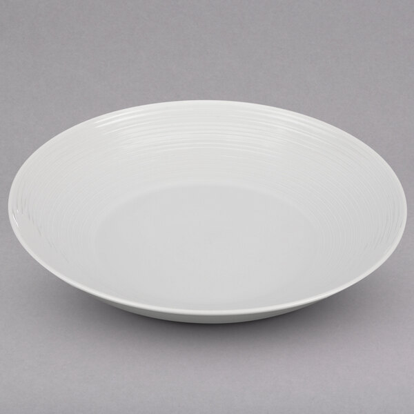A Oneida Botticelli deep plate with a curved surface and thin rim on a white background.