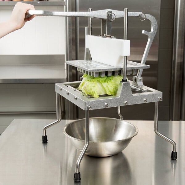 A Vollrath Lettuce King machine cutting lettuce into a bowl.
