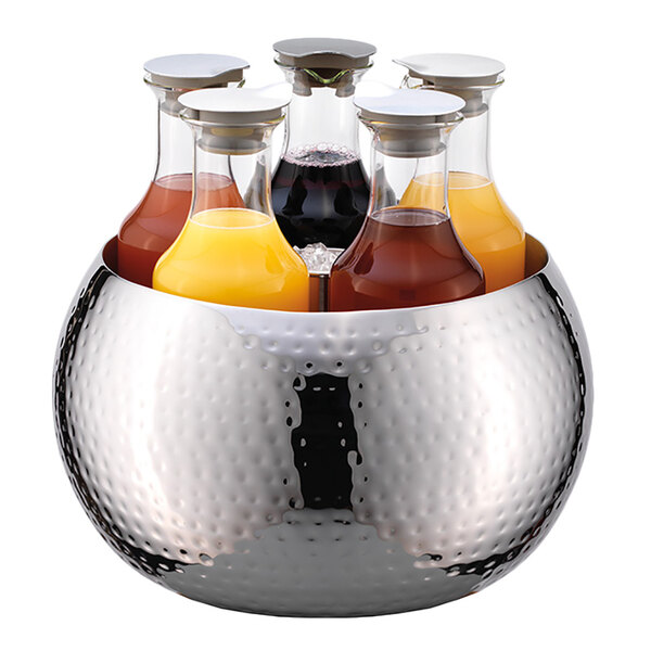 A Frilich stainless steel beverage tub with six carafes filled with drinks.