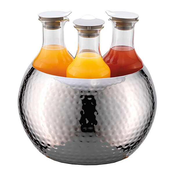 A group of Frilich stainless steel carafes in a metal bowl with orange and red liquid.