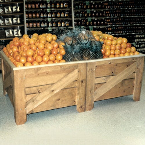A Marco Company wooden produce display bin filled with oranges and pineapples.