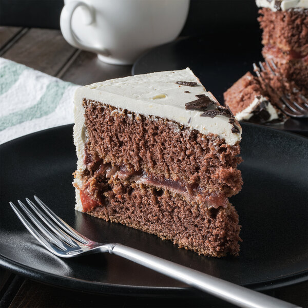A close-up of a slice of Pellman Black Forest Cake on a plate with a fork.