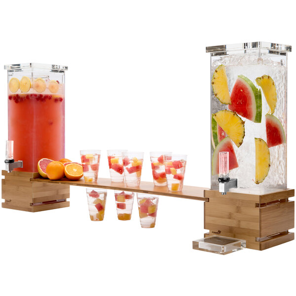A wooden bar with two Rosseto bamboo drink dispensers filled with fruit and drinks.