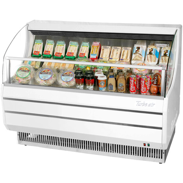 A Turbo Air white horizontal air curtain display case with food inside.