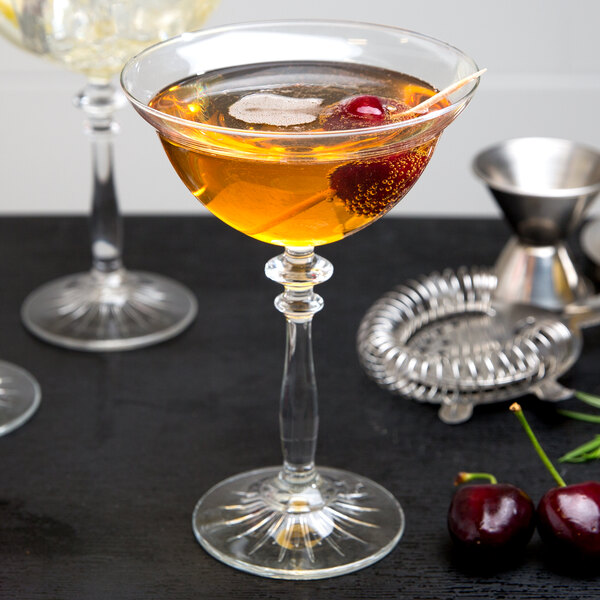 A Libbey Coupe Cocktail Glass with a drink and a cherry on top.