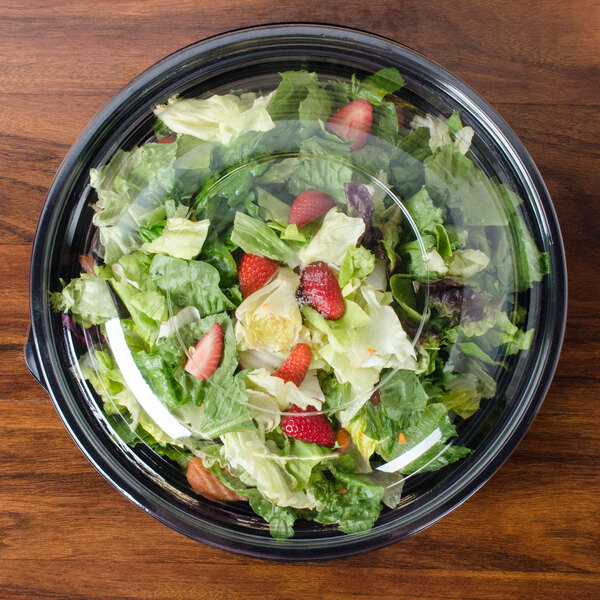 A salad in a Sabert FreshPack clear plastic bowl with a dome lid.
