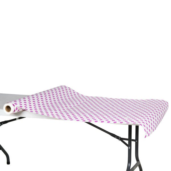 A table with a purple polka dot tablecloth made of paper.