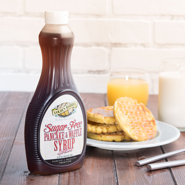 A Golden Barrel Sugar Free Pancake and Waffle Syrup bottle on a table next to a plate of waffles.