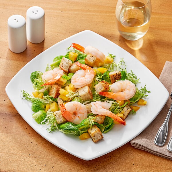 An Acopa Bright White square porcelain plate with shrimp salad on it.