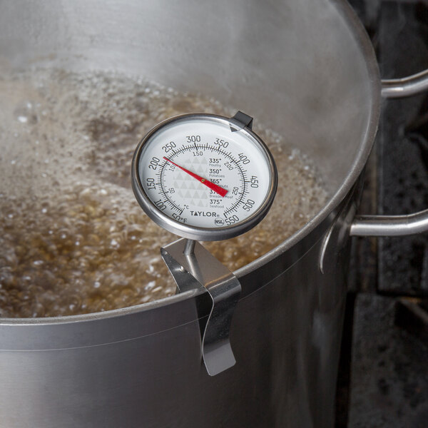 A Taylor candy and deep fry thermometer in a pot of boiling water.