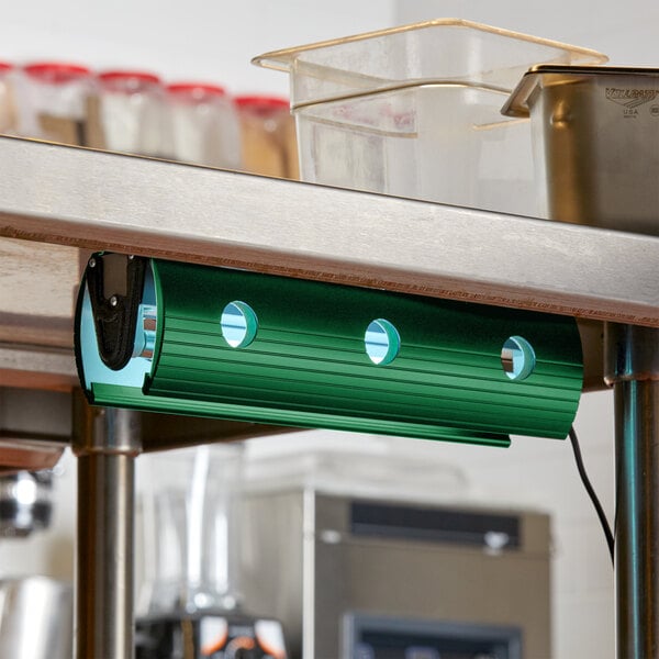 A Curtron green UV flying insect light on a metal counter top.