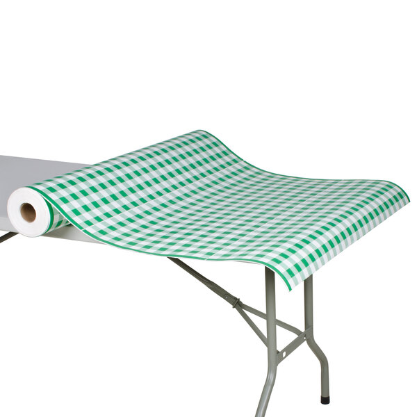 A roll of green and white checkered paper table cover on a table.