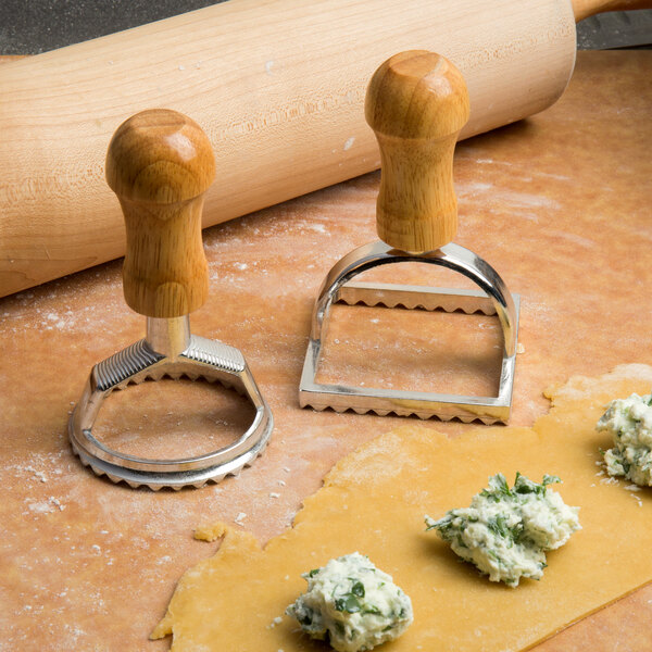 A rolling pin and ravioli cutters used to cut pasta.
