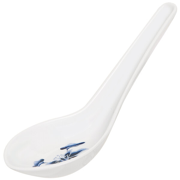 A white melamine soup spoon with blue water lilies on it.