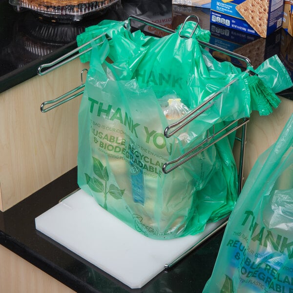 A plastic bag of food in a Choice Chrome T-Shirt Bag rack.
