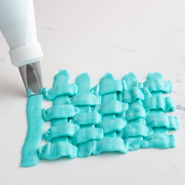 A close-up of blue icing with a braided pattern made with an Ateco 45 Basketweave piping tip.