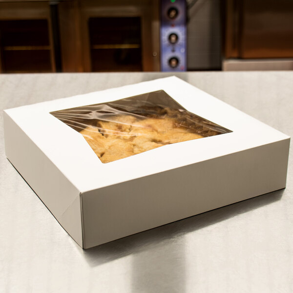A white bakery box with a clear plastic window containing food.