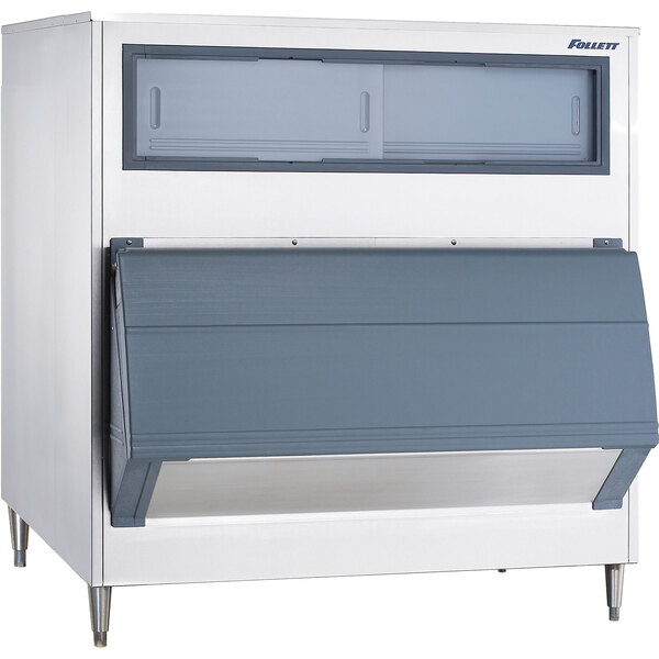 A large white and grey Follett upright ice storage bin with a grey door open.
