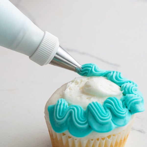 A cupcake with blue frosting piped using an Ateco Left-Handed Curved Petal Piping Tip.
