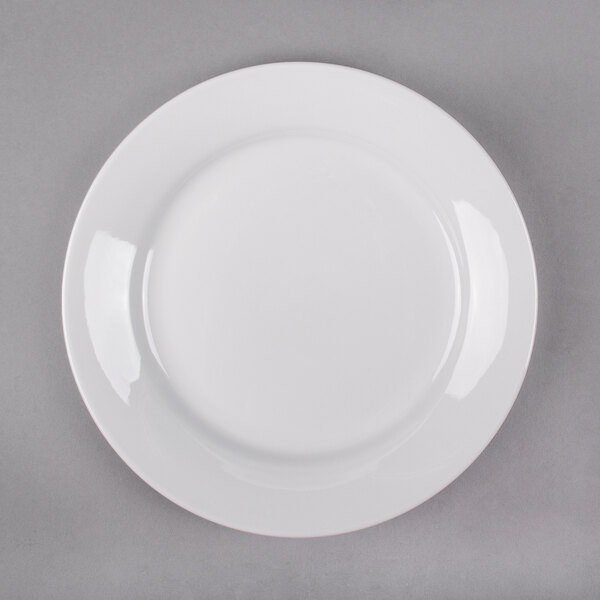 A white plate with a white rim on a gray surface.