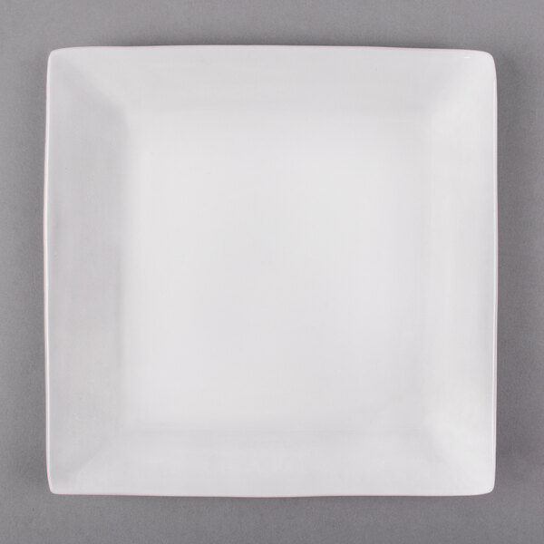 A white Libbey square porcelain plate with a white rim on a gray surface.