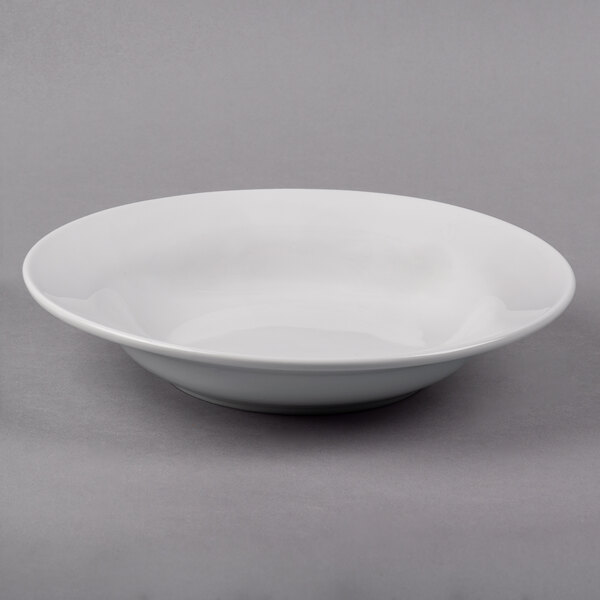 A Libbey Lunar Bright white porcelain soup bowl with a rim on a gray surface.
