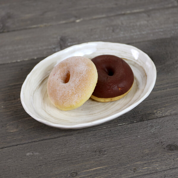 An Elite Global Solutions Van Gogh taupe oval melamine plate with two donuts on it.