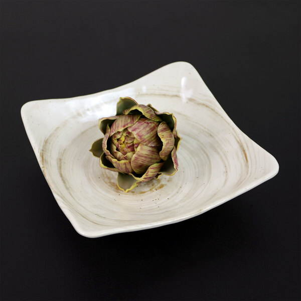 A square taupe melamine bowl with an artichoke on it.