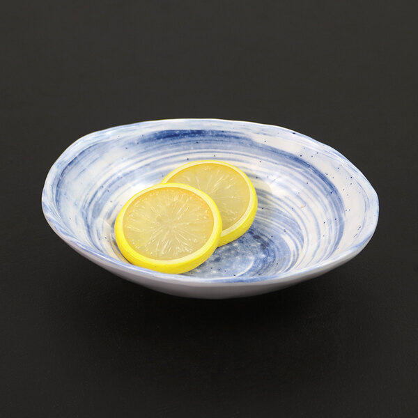 An Elite Global Solutions Van Gogh navy melamine bowl with lemon slices in it.