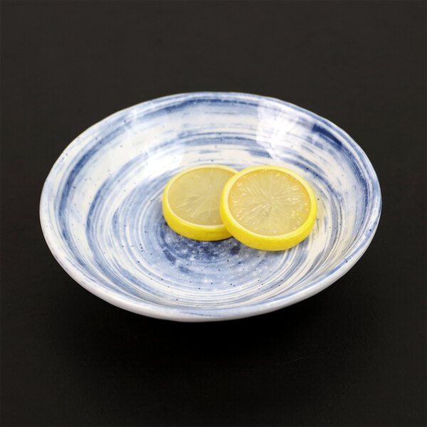 An Elite Global Solutions Van Gogh navy melamine bowl with lemon slices on it.