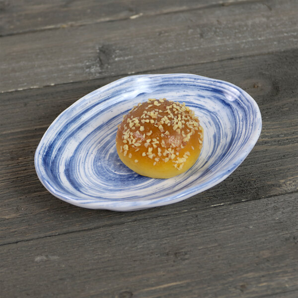 An Elite Global Solutions oval navy melamine plate with a bread roll on it.
