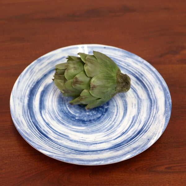 An artichoke on a blue and white Elite Global Solutions Van Gogh melamine plate.