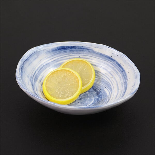 An Elite Global Solutions oval melamine bowl with lemon slices in it.
