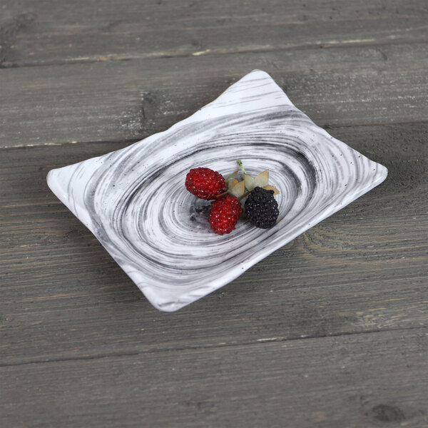 A rectangular black melamine plate with berries on it.
