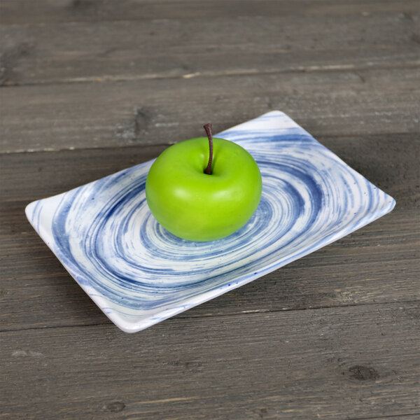 An Elite Global Solutions Van Gogh navy rectangular melamine plate with a green apple on it.