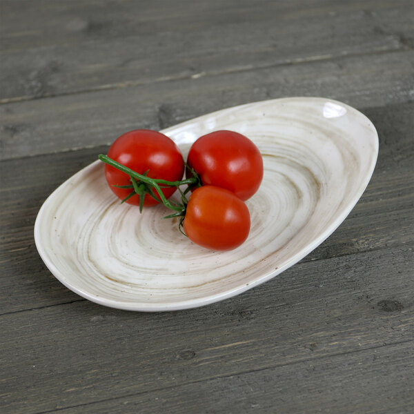 An Elite Global Solutions taupe oval melamine plate with tomatoes on it.